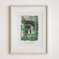 a couple standing on a balcony surrounded by greenery in a white frame, with the bride and groom holding each other close together