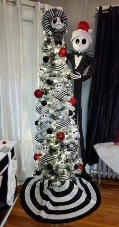 a christmas tree decorated with black and white striped ornaments, red balls and skulls on it