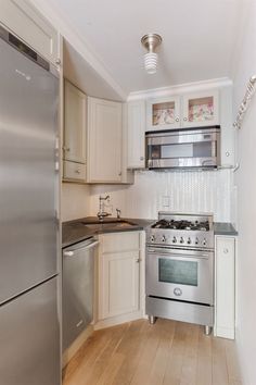 an empty kitchen with stainless steel appliances and wood flooring on the wooden floored floors