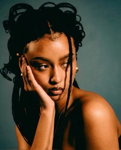 a woman with dreadlocks on her head posing for the camera