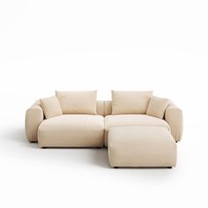 a white couch with pillows and a footstool in front of a white background