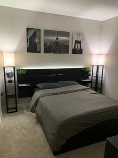 a bed sitting in a bedroom next to two pictures hanging on the wall above it