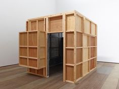 an open bookcase sitting on top of a hard wood floor next to a white wall