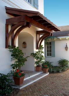 an outside view of a house with potted plants