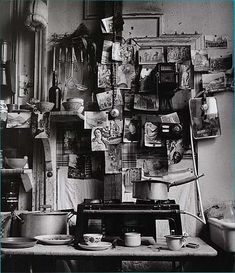 an old kitchen with pots and pans hanging on the wall, in black and white