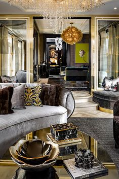 a living room filled with lots of furniture and a chandelier hanging from the ceiling