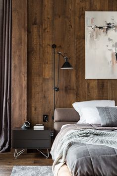 a bedroom with wood paneling and a large painting on the wall above the bed