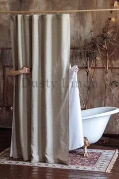 a bathroom with a bathtub, rug and shower curtain in front of the tub