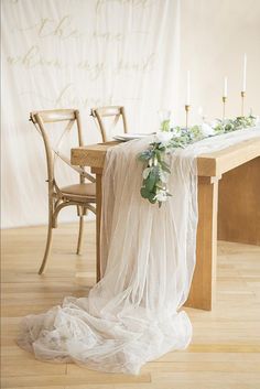 the table is set with candles and greenery for an elegant wedding reception at long's