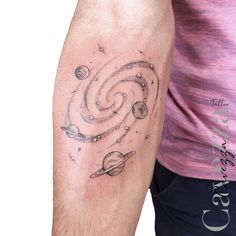 a man with a tattoo on his arm that has planets and stars in the sky