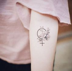 a woman's arm with a cross and flower tattoo on the left inner arm