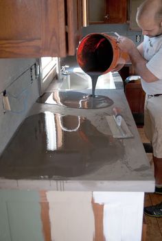 a man is pouring something into a sink