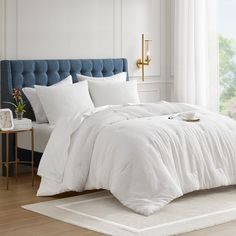 a bed with white sheets and pillows in a room