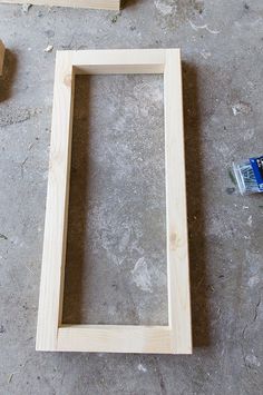 the unfinished frame is sitting on the floor next to some construction materials and glues