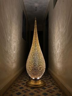 a large glass vase sitting in the middle of a hallway