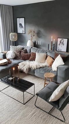 a living room filled with lots of furniture and candles on the coffee table in front of it