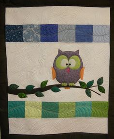 an owl is sitting on a branch with green leaves and blue squares in the background