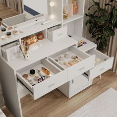 a white vanity with drawers and lights on the top shelf in front of a plant