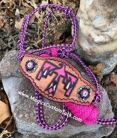 a pink and black handbag sitting on top of a rock