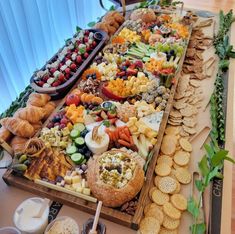 an assortment of snacks and crackers on a buffet table with blue curtains in the background