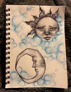 a drawing of two faces with the sun and moon above them on a sheet of paper