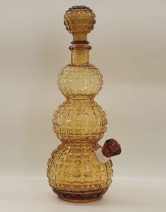 a yellow glass bottle sitting on top of a white table next to a brown object