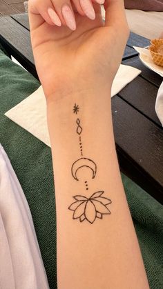 a woman's arm with a tattoo on it and a flower in the middle