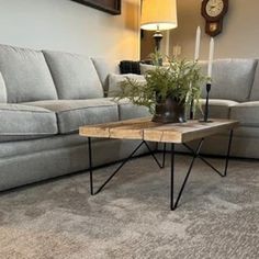 a living room with a couch, coffee table and clock on the wall behind it