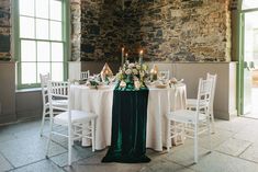 the table is set with white and green linens