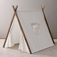 a teepee tent sitting on top of a white floor next to a wooden pole