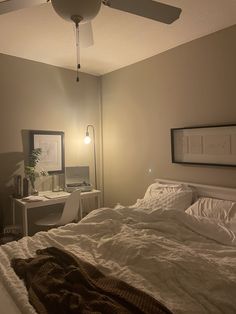 a bedroom with a bed, desk and ceiling fan