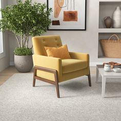 a yellow chair sitting in front of a white coffee table on top of a rug