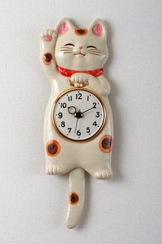 a white cat clock hanging on the wall