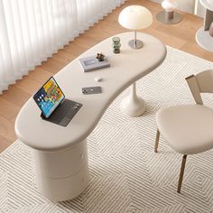 a laptop computer sitting on top of a white desk next to a chair and lamp