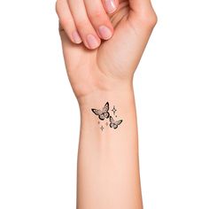 a woman's arm with a small butterfly tattoo on the left side of her wrist