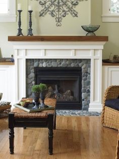 a living room filled with furniture and a fire place in front of a mantle covered in rocks