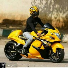 a man riding on the back of a yellow motorcycle