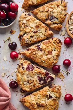 sliced cherry almond scones on a table with cherries