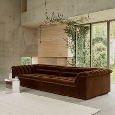 a large brown couch sitting in front of a window