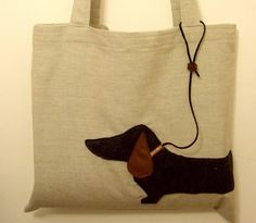 a bag with a dachshund on it hanging from the wall next to a white wall