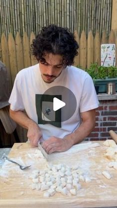 a man making food on top of a wooden table