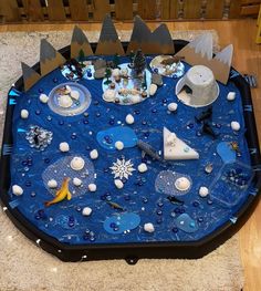 a blue table topped with lots of toys and snowflakes on top of it