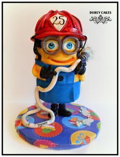 a cake made to look like a minion wearing a fireman's helmet