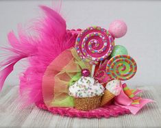 a pink hat with candy and lollipops on it