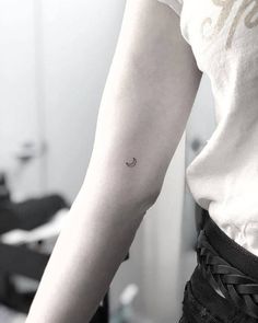 a woman with a small crescent tattoo on her arm