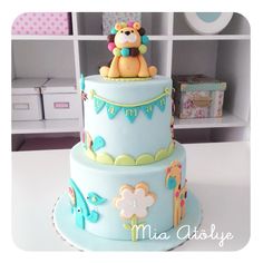 a three tiered cake decorated with a teddy bear and other animals on it's sides