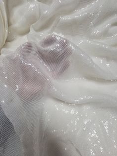 white fabric with silver sequins on it