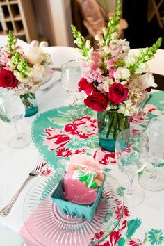 the table is set with pink and red flowers