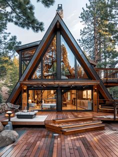 a wooden deck with stairs leading up to a large triangular shaped house in the woods