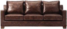 a brown leather couch sitting on top of a wooden floor